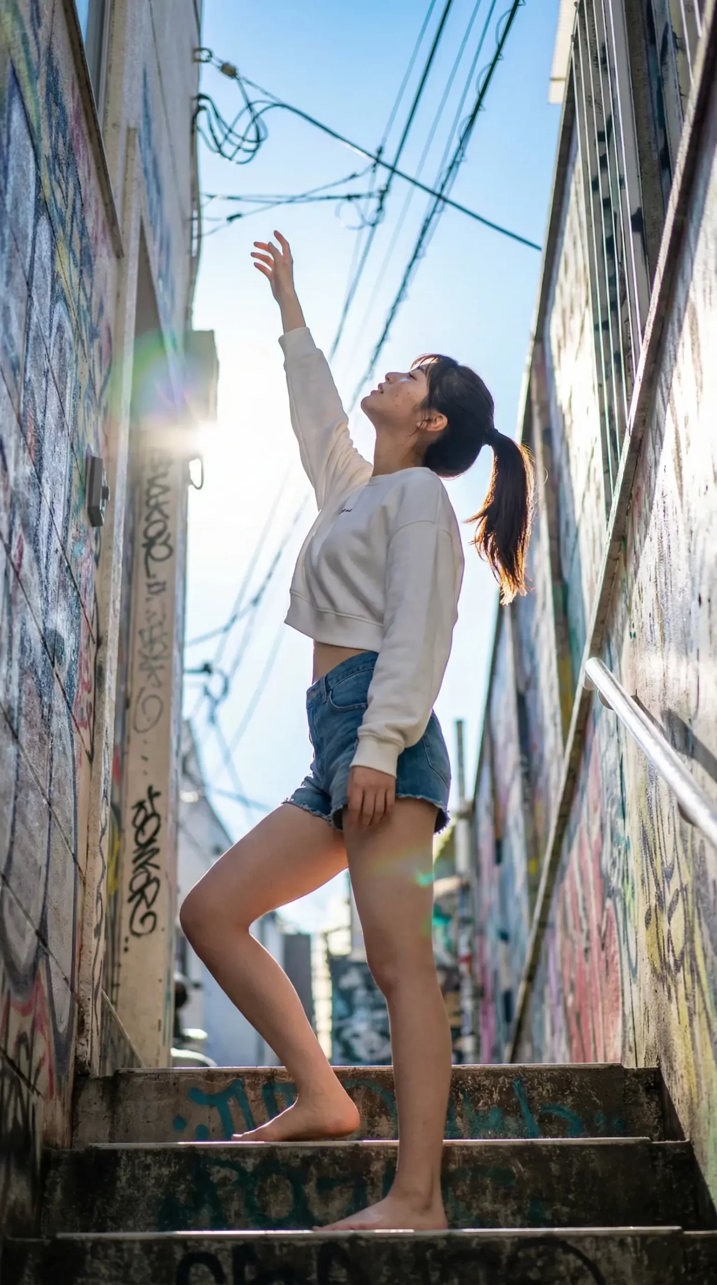 階段を上る女性が手を伸ばす