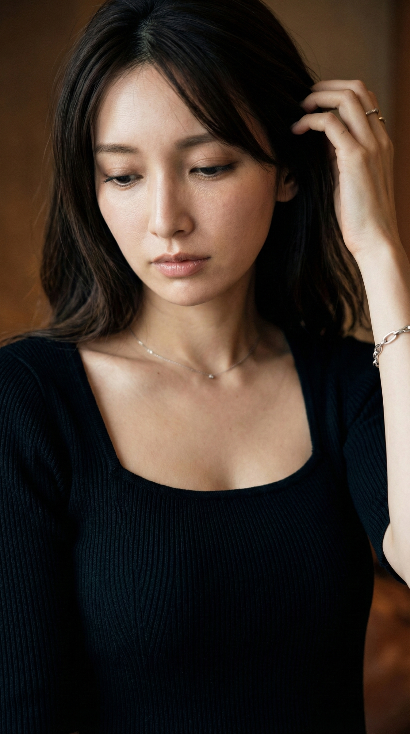 黒い服を着て髪に触れる女性