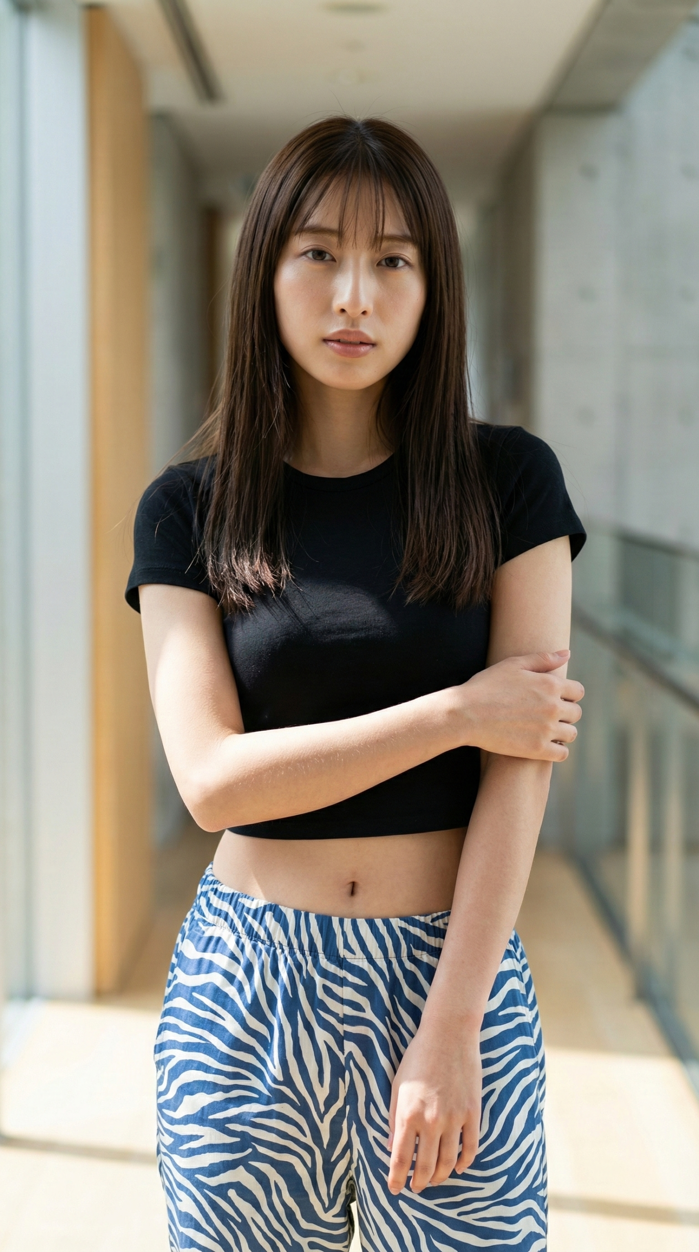 黒いクロップドTシャツとゼブラ柄パンツの女性