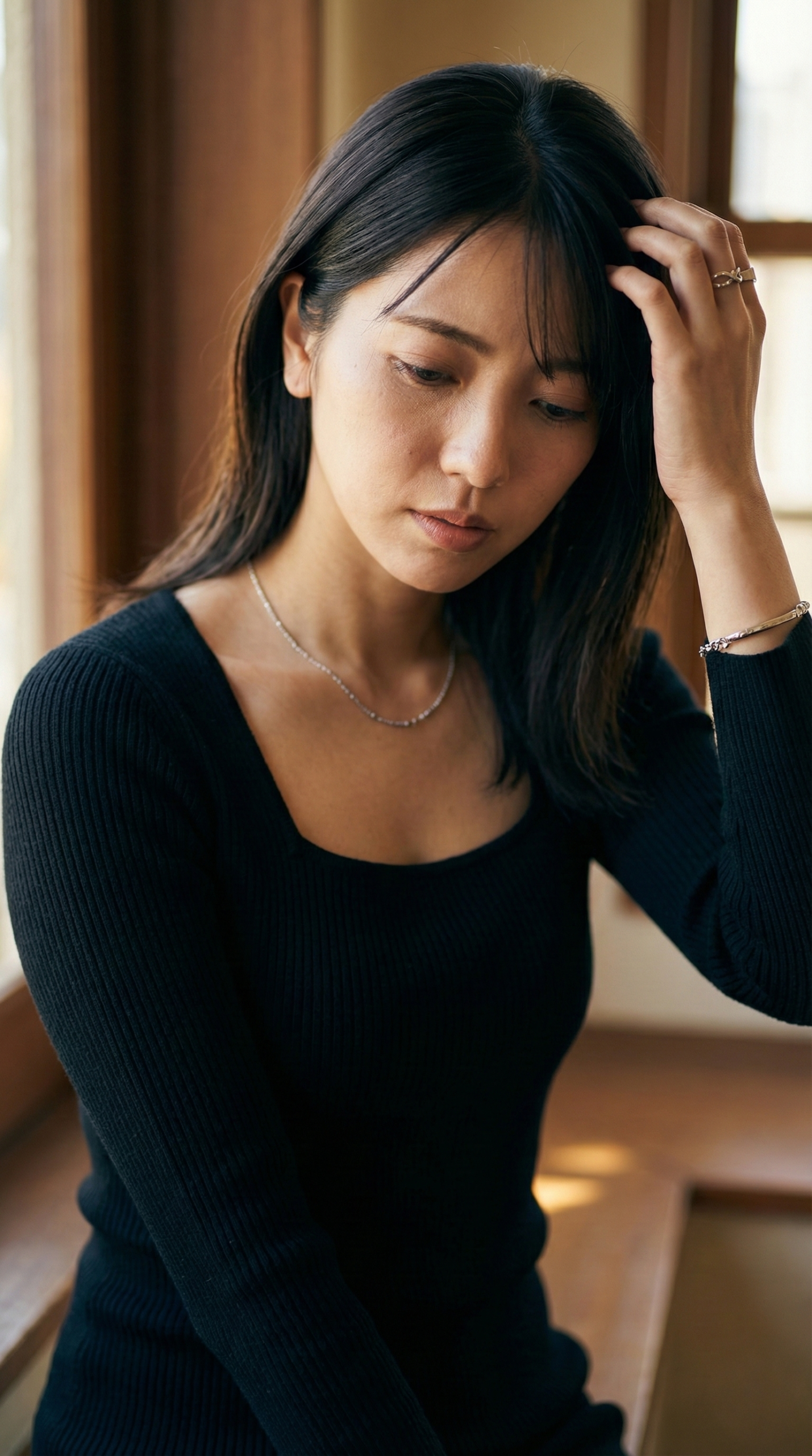 窓辺で物思いにふける女性