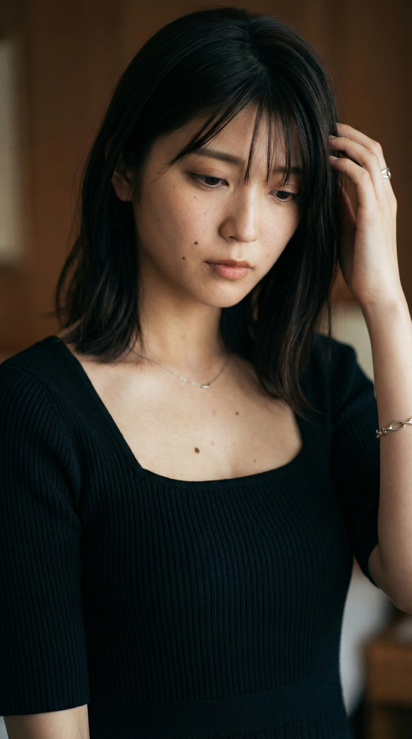 黒い服を着た女性が髪に触れている