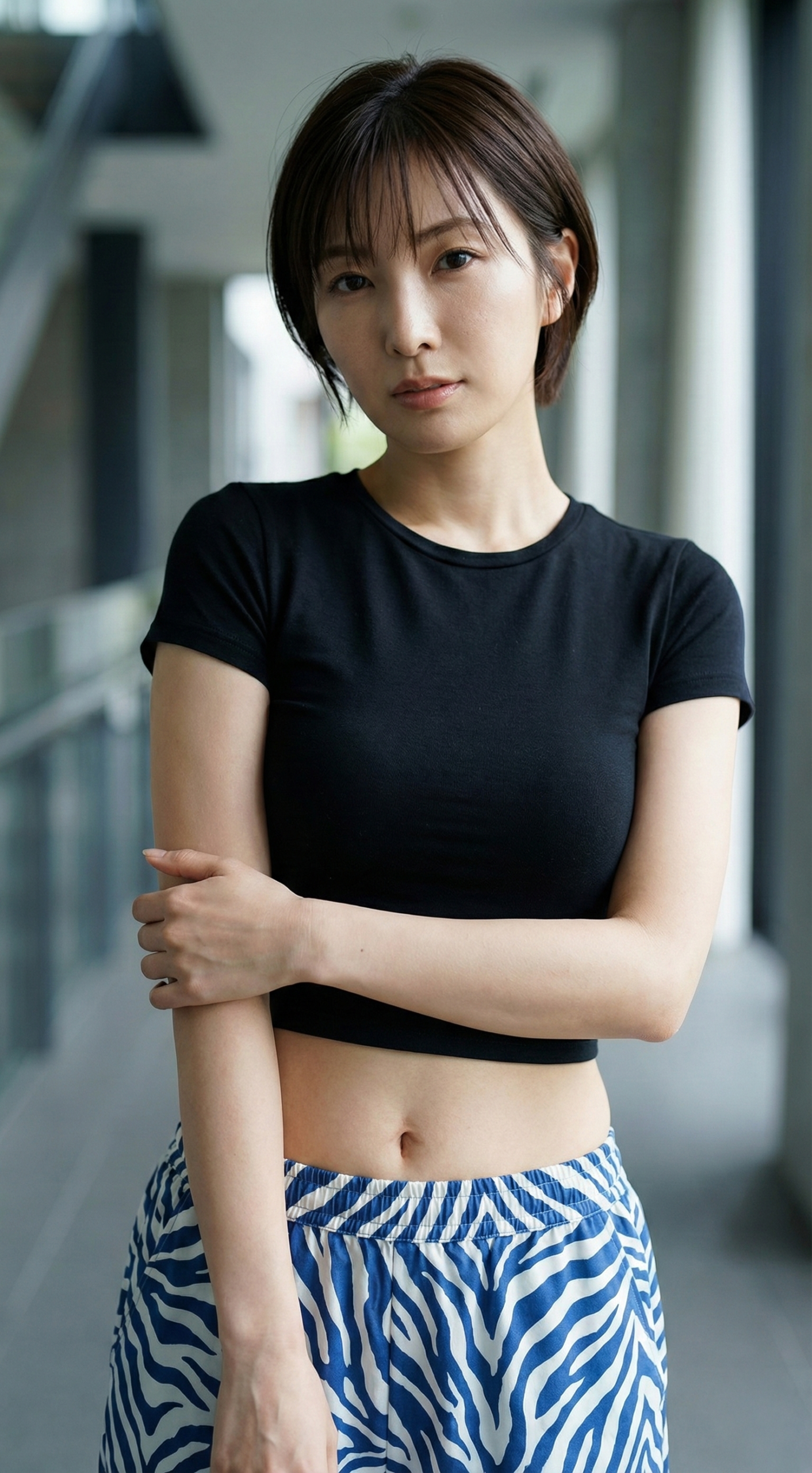 黒いクロップドTシャツとゼブラ柄パンツの女性