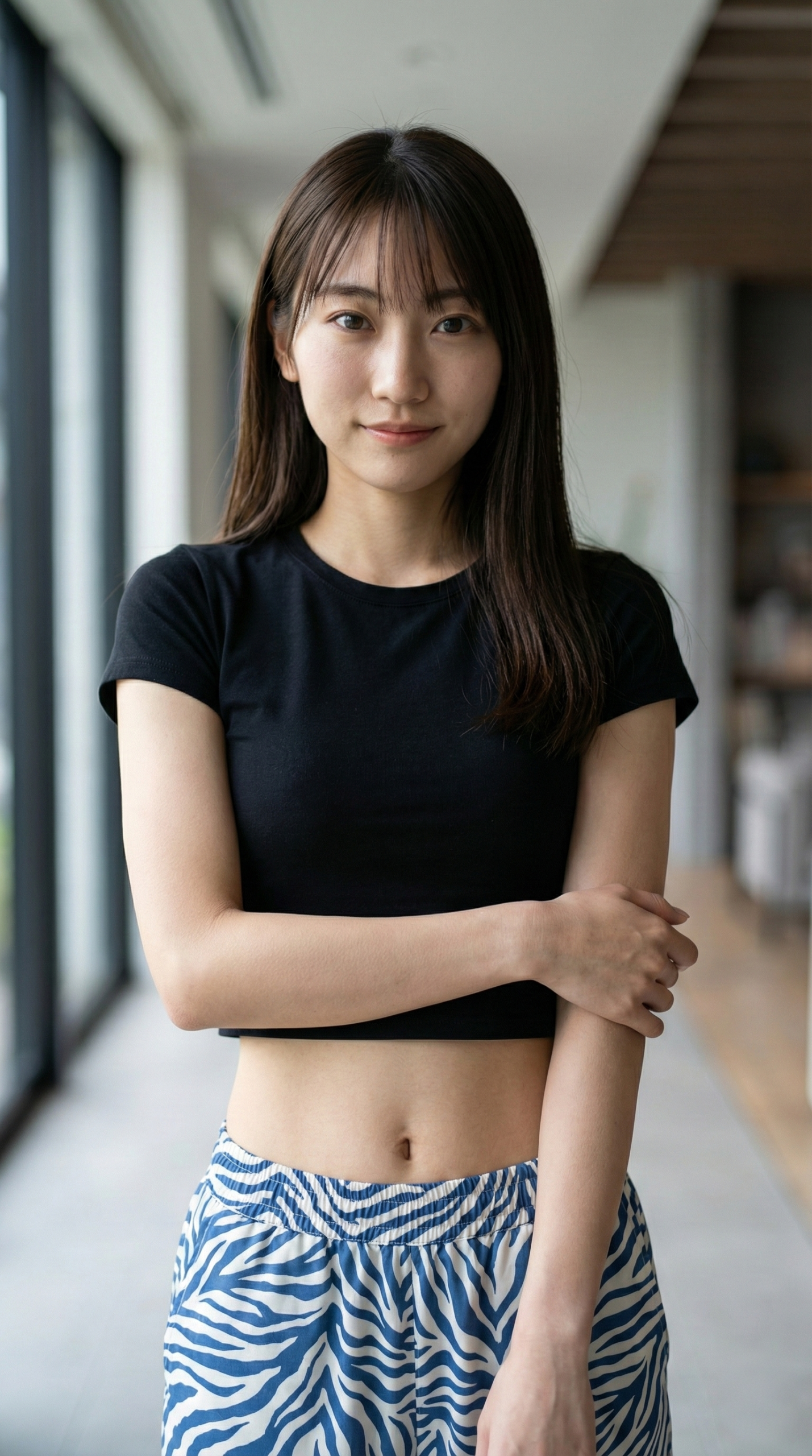 黒いクロップトップとゼブラ柄パンツの女性