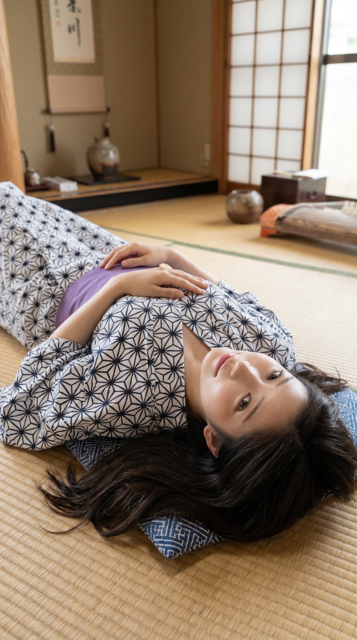 浴衣姿の女性が和室の畳の上で仰向けに横たわり、こちらを見つめている