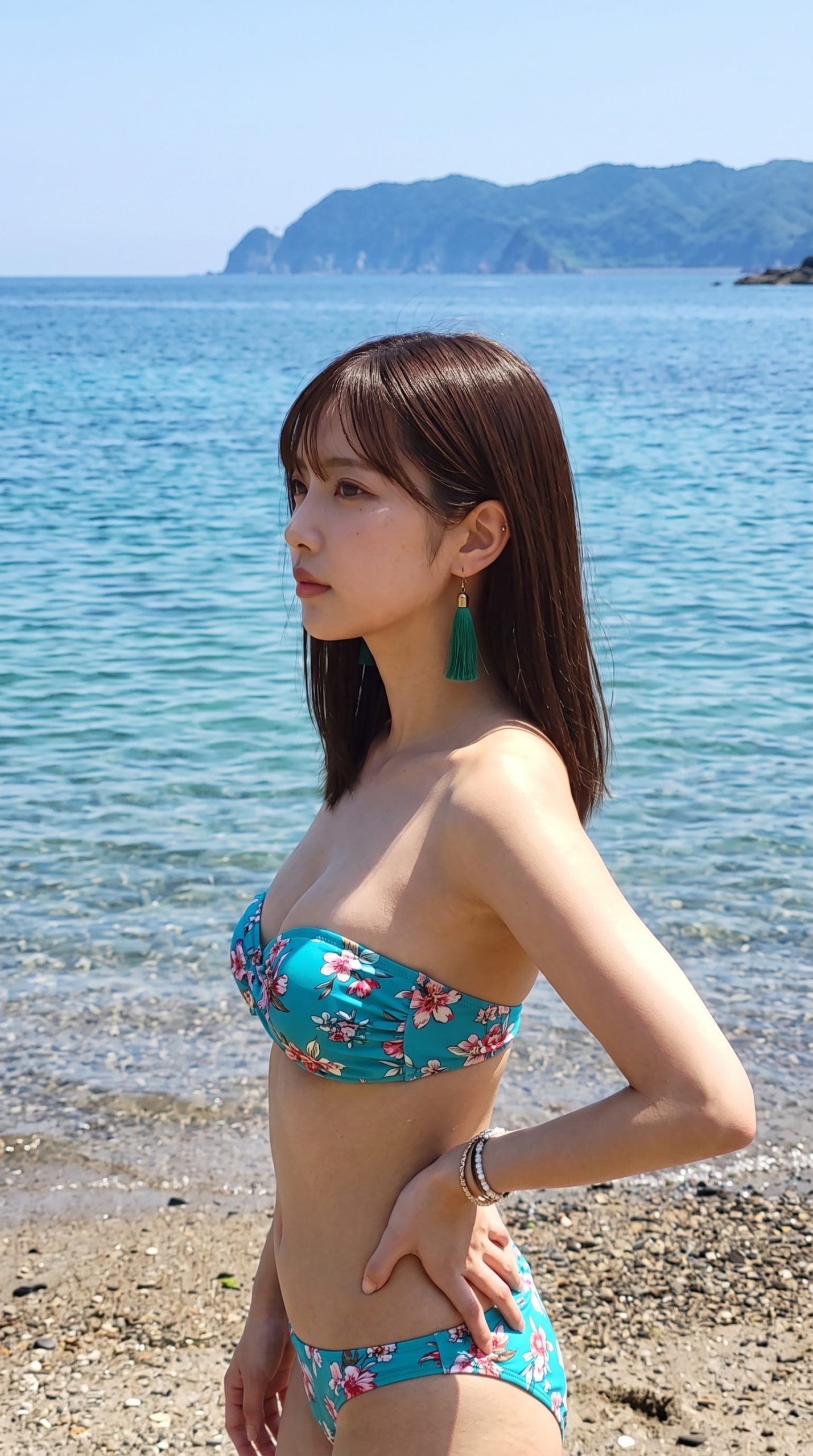 青い海を背景に、花柄の水着を着て砂浜に立つ女性