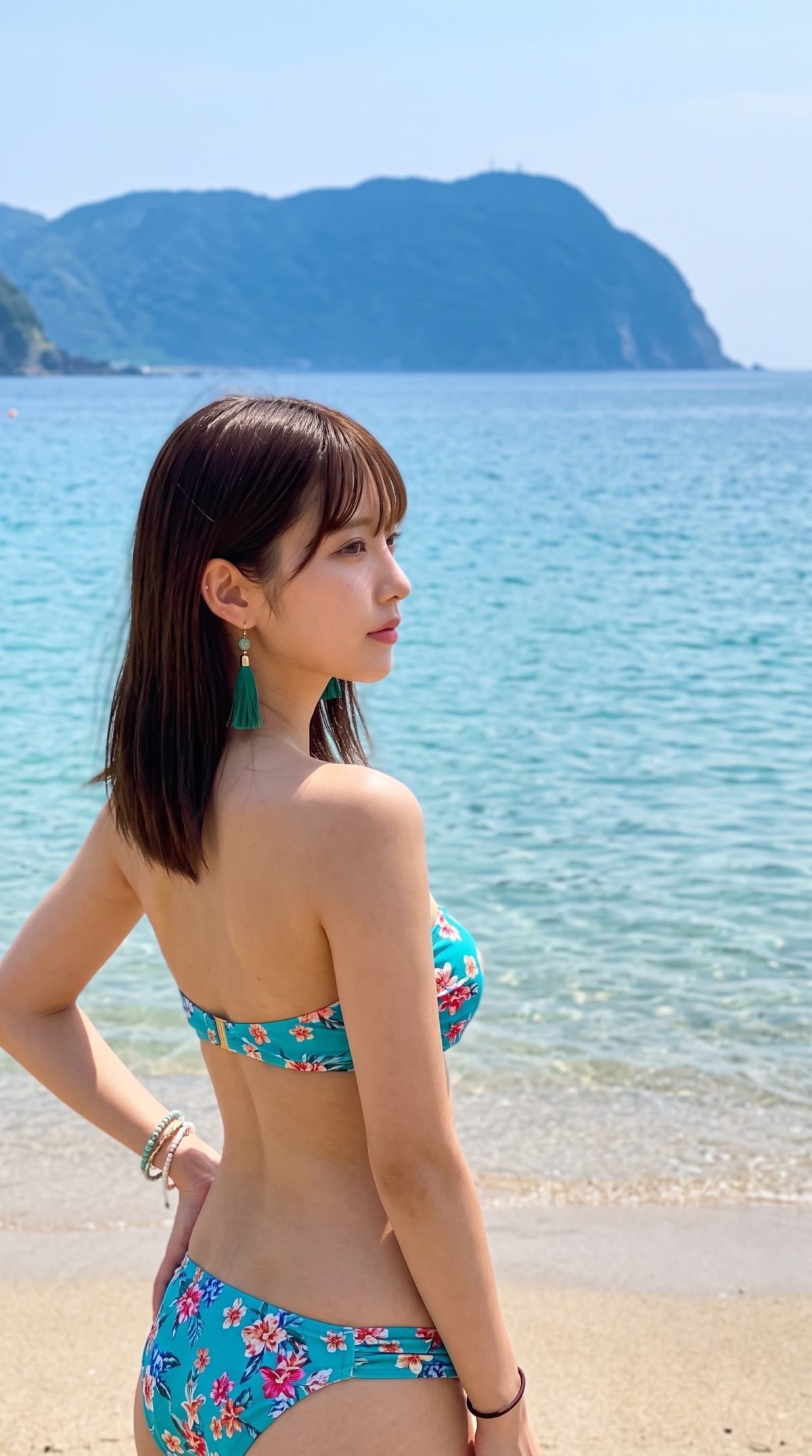 青い海と砂浜を背景に、花柄の水着を着て佇む女性の横顔